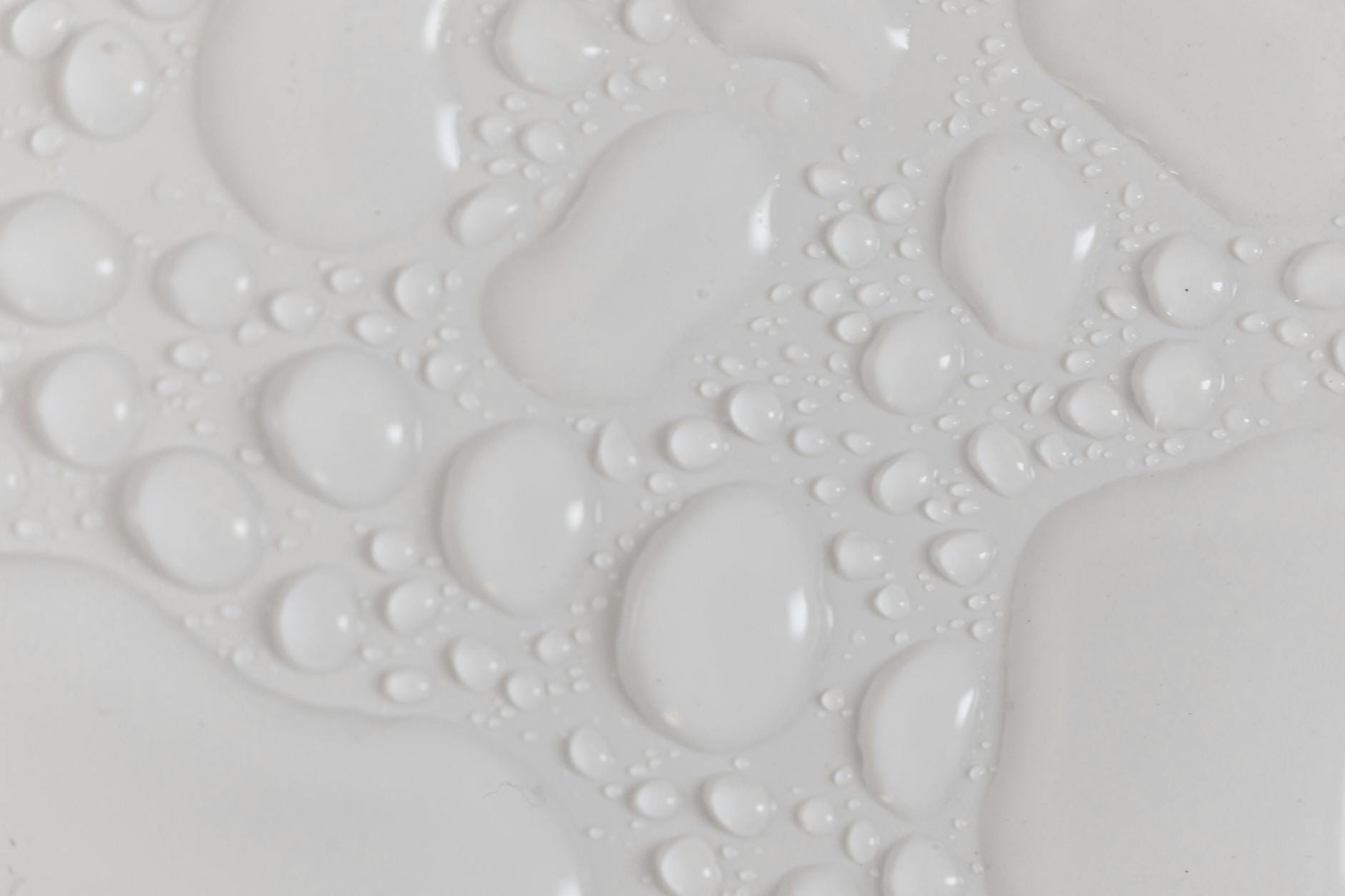 Zbliżenie kropli wody na białej, mokrej powierzchni