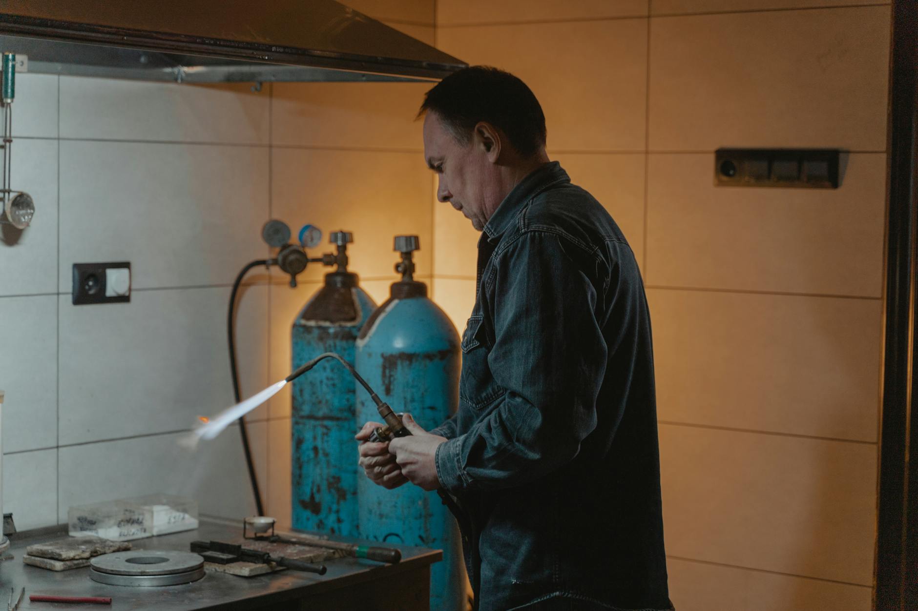 Serwisant spawa element instalacji w przemysłowej hali