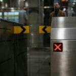 Zbliżenie na stalową bramkę z czerwonym symbolem zakazu przejścia